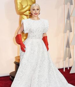 Lady Gaga arrived to Sunday's Academy Awards wearing a white Azzedine Alaïa gown paired with shiny red gloves